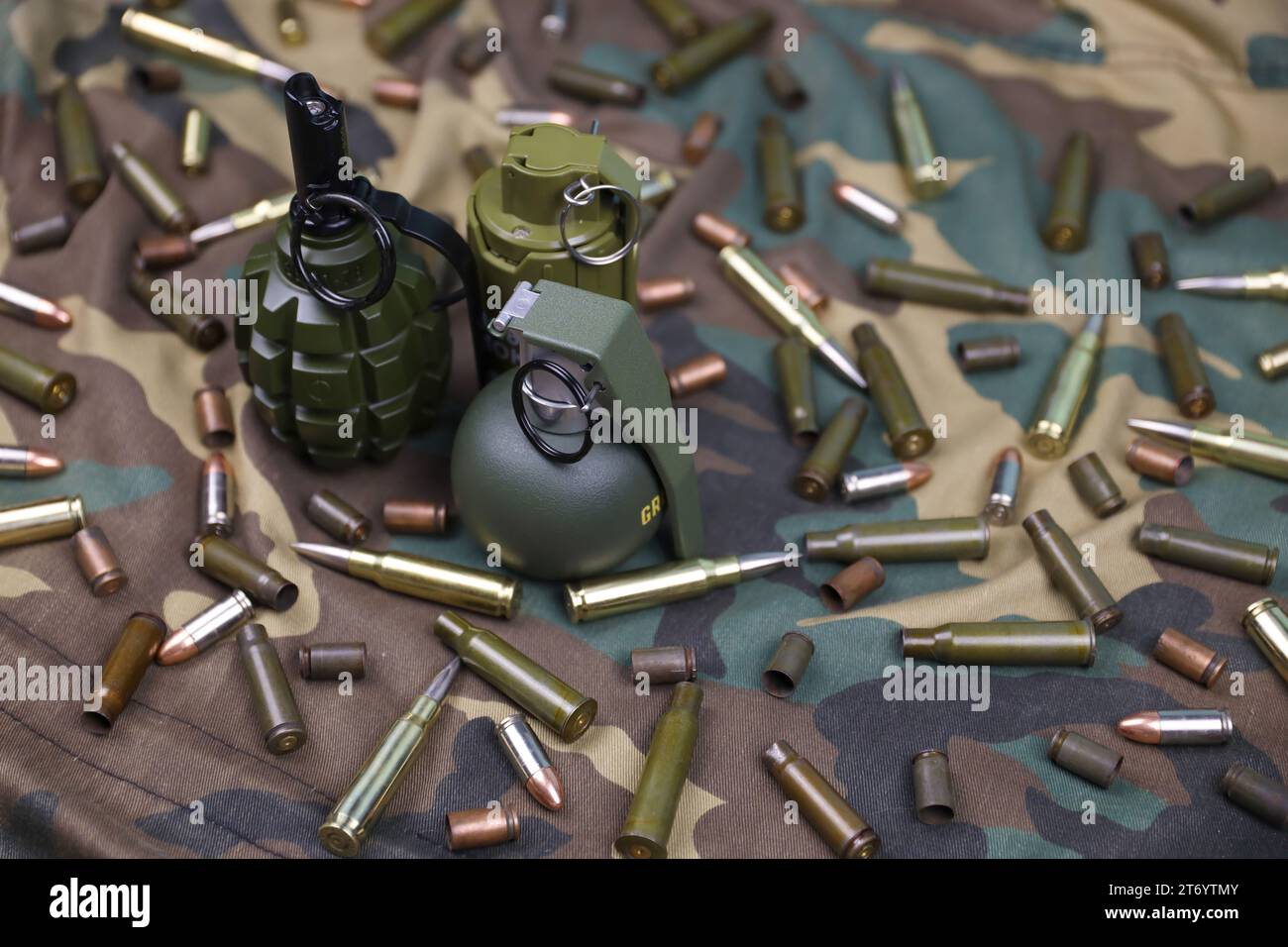 Different types of ammunition and grenades on a camouflage background