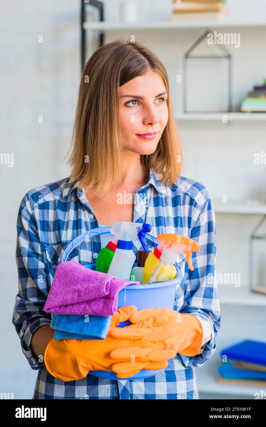 Portrait female janitor holding cleaning equipment bucket Stock Photo