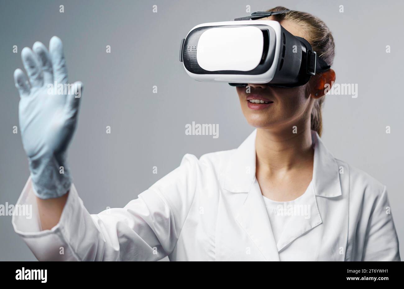 Smiley female researcher using virtual reality headset Stock Photo