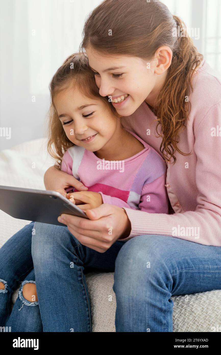 Two sisters using tablet together home Stock Photo