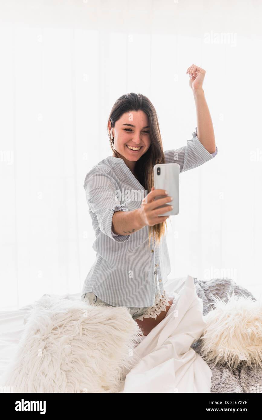 Young woman making video call smartphone dancing Stock Photo