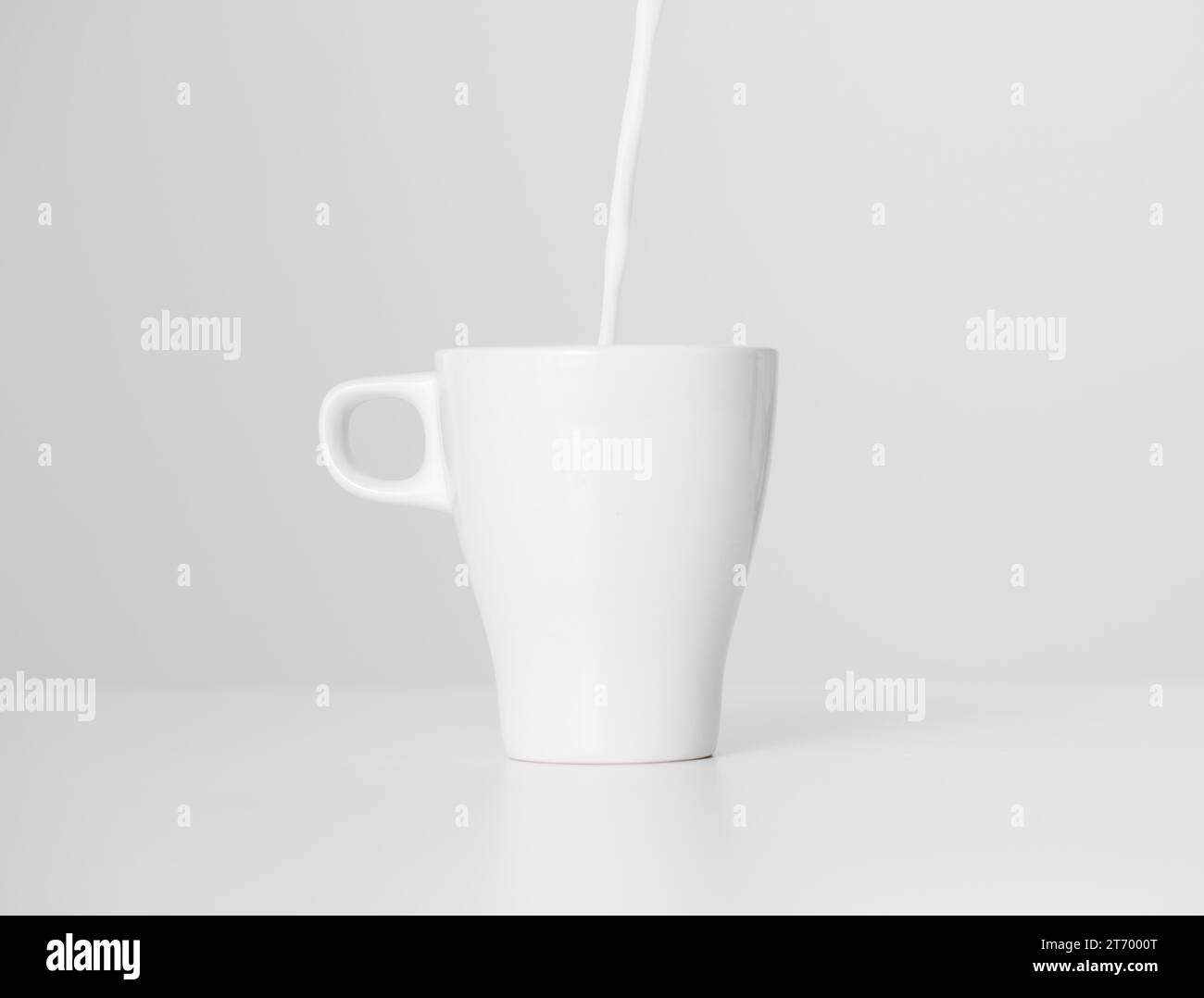 Close up milk pouring into ceramic cup Stock Photo Alamy