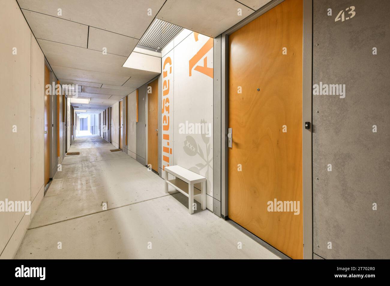 an empty hallway with orange and white paint on the walls, and a sign that says no one is there Stock Photo