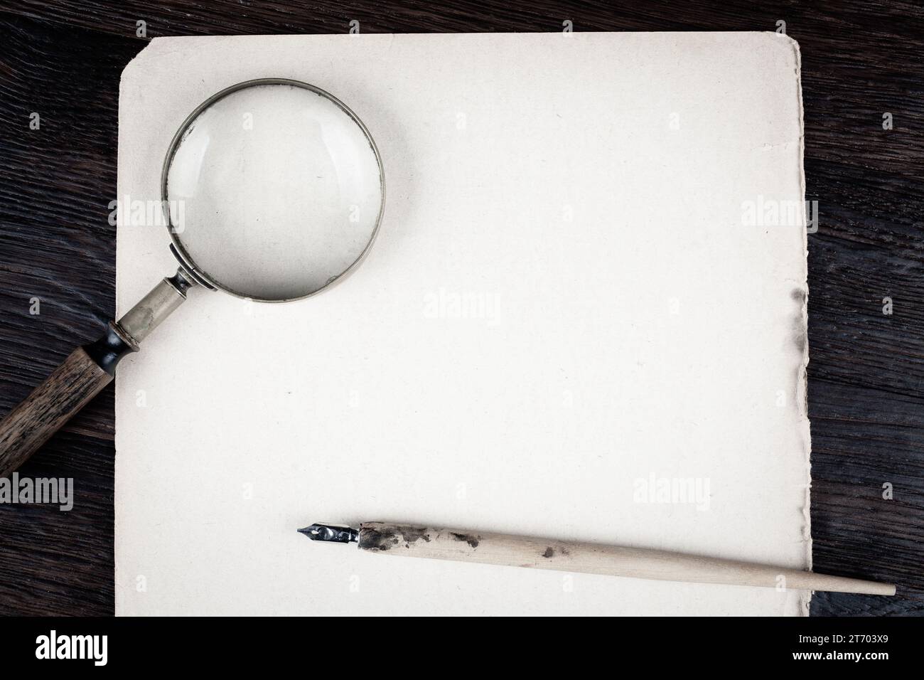 Magnifying glass with old ink feather pen on paper background Stock ...