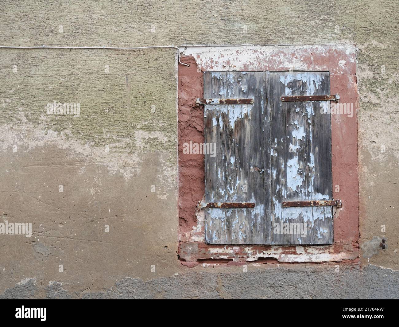 Window in an old plastered house wall with closed wooden shutters Stock ...