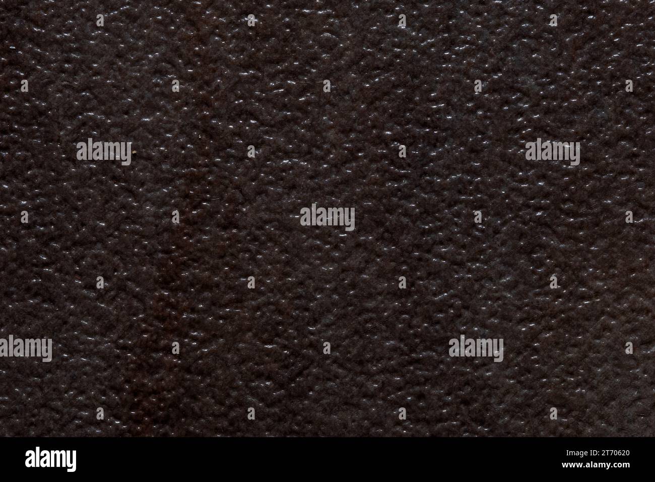 Dark textured background image resembling divoted or dimbled brown stone. Stock Photo