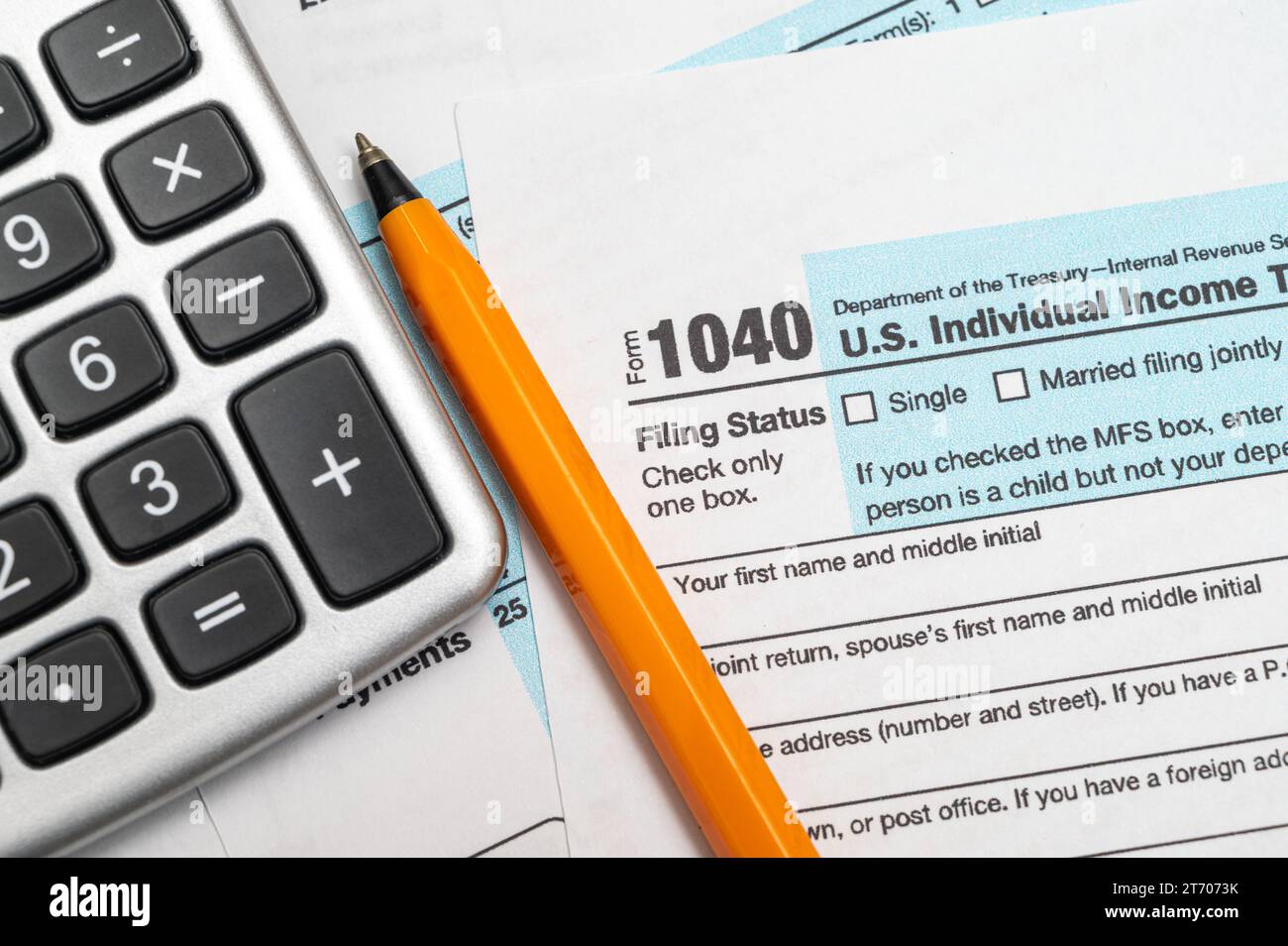 A man organizing individual income tax return form 1040 and receipts. Blurred background. Tax time.Tax concept. Close-up. Stock Photo