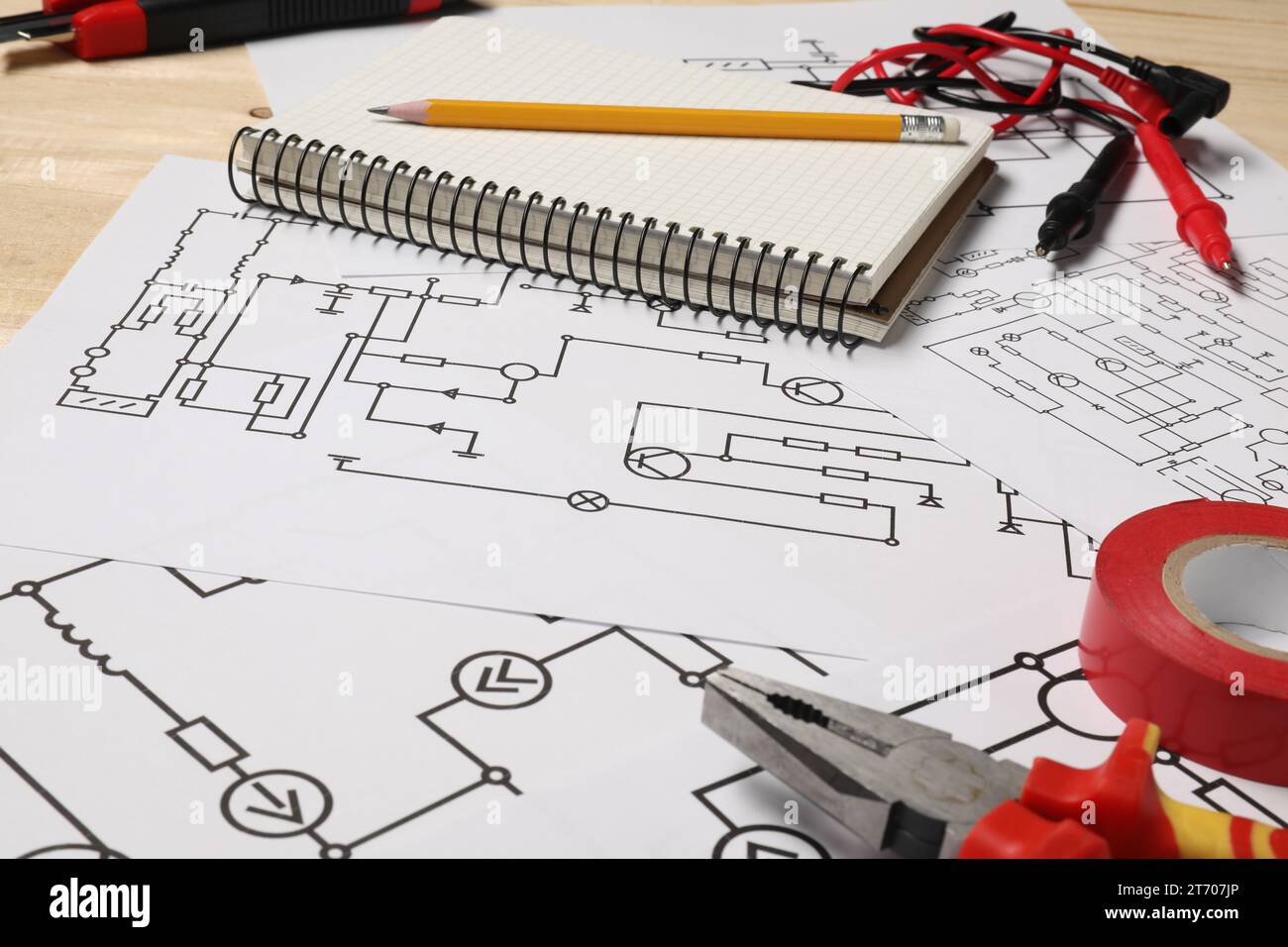 Wiring diagrams, tools and office stationery on wooden table, closeup
