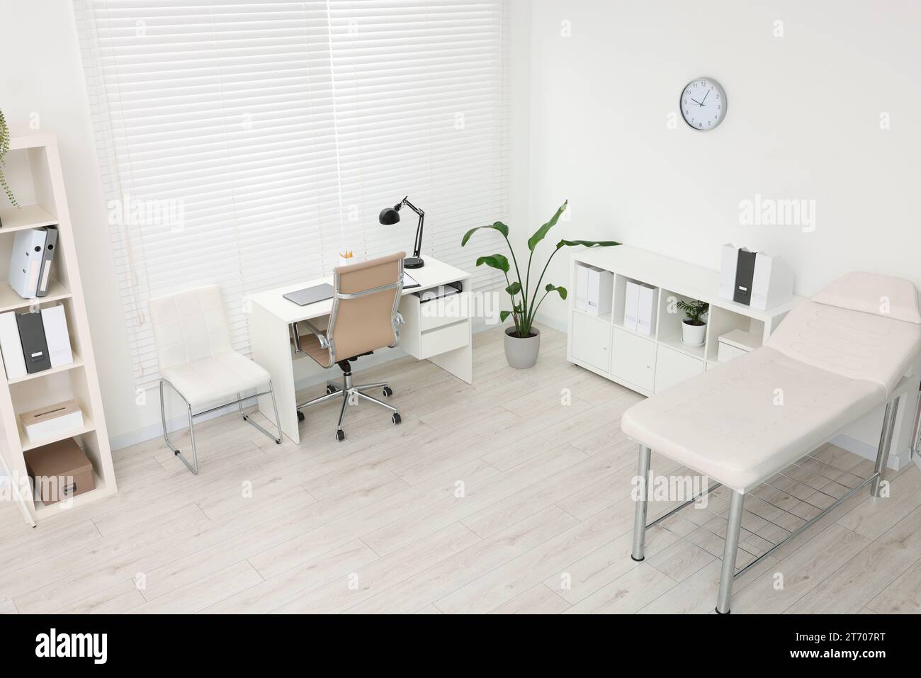 Modern medical office with doctor's workplace and examination table in ...