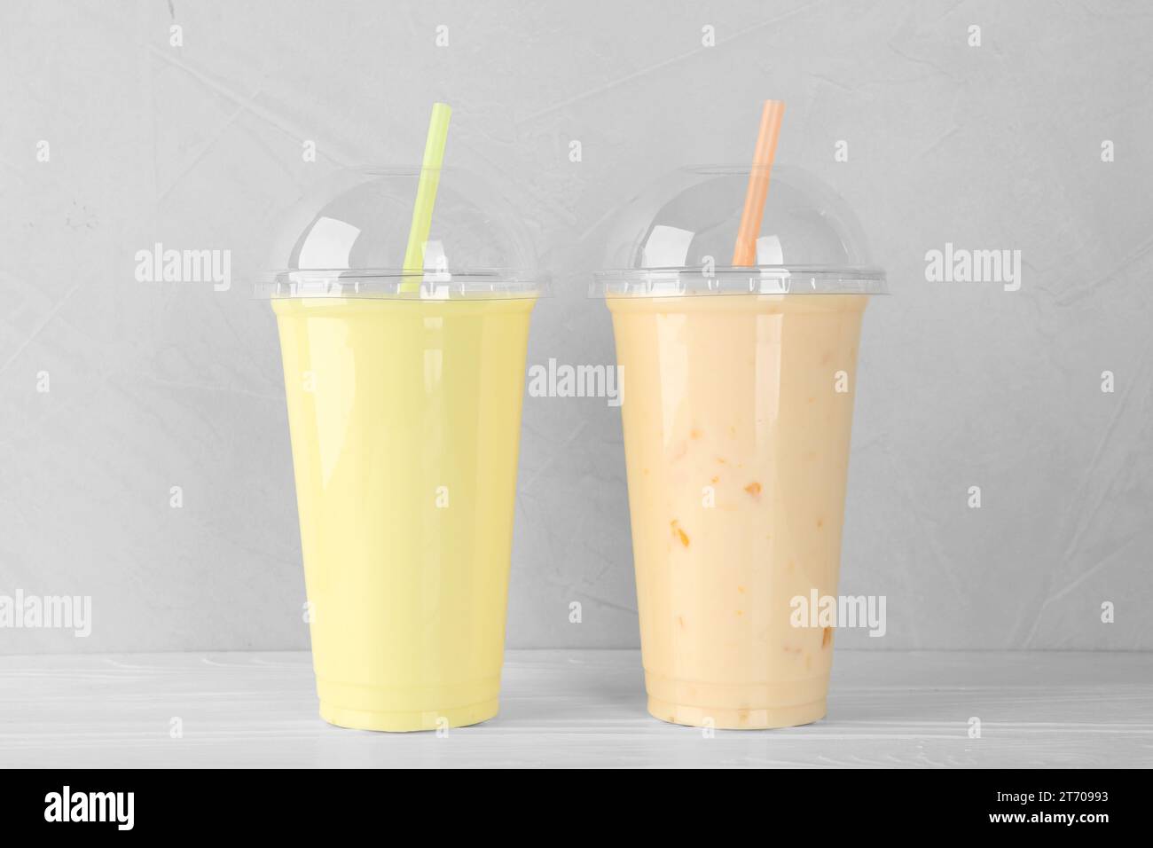 https://c8.alamy.com/comp/2T70993/plastic-cups-of-different-tasty-smoothie-on-white-wooden-table-2T70993.jpg