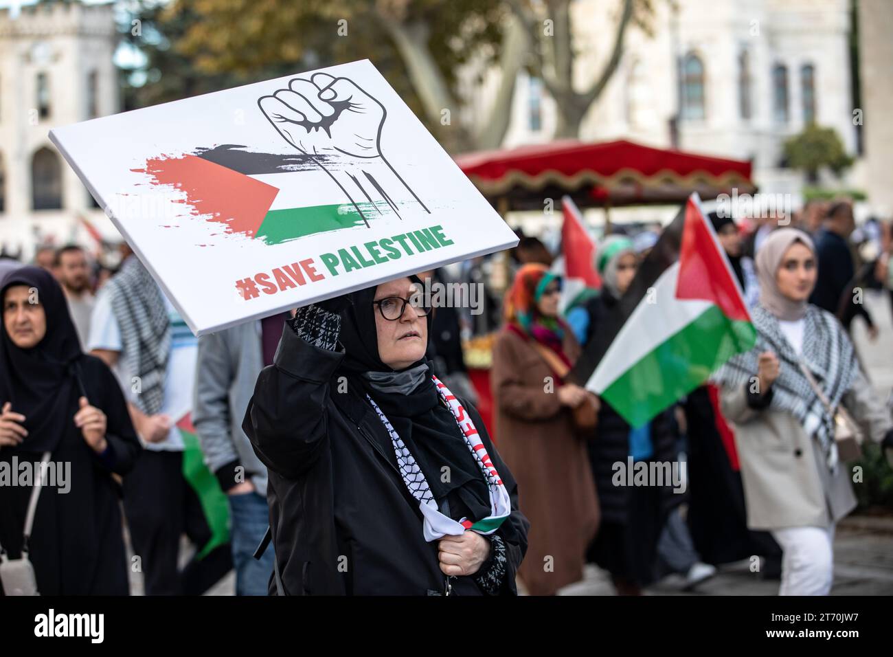 Istanbul, Turkey. 12th Nov, 2023. A protester was seen carrying a Palestinian flag saying 'save Palestine' and a banner depicting a fist. Palestine Initiative Platform formed a human chain from Edirnekapi to Sultanahmet to protest Israel's attacks on Gaza. Credit: SOPA Images Limited/Alamy Live News Stock Photo