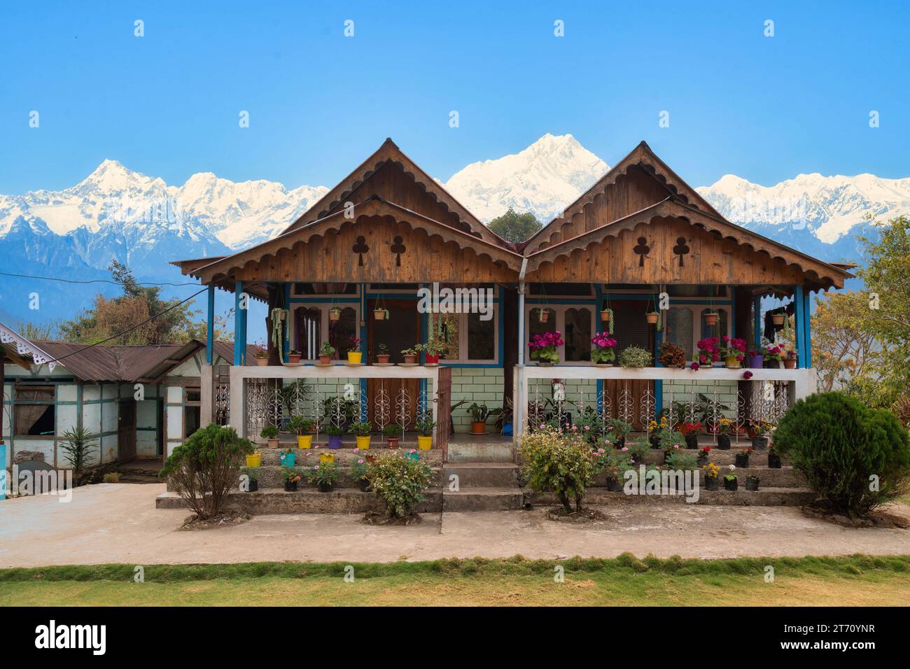 Beautiful wooden houses with Kanchenjunga Himalaya mountain range in the background at Tinchuley, Darjeeling, India. Stock Photo
