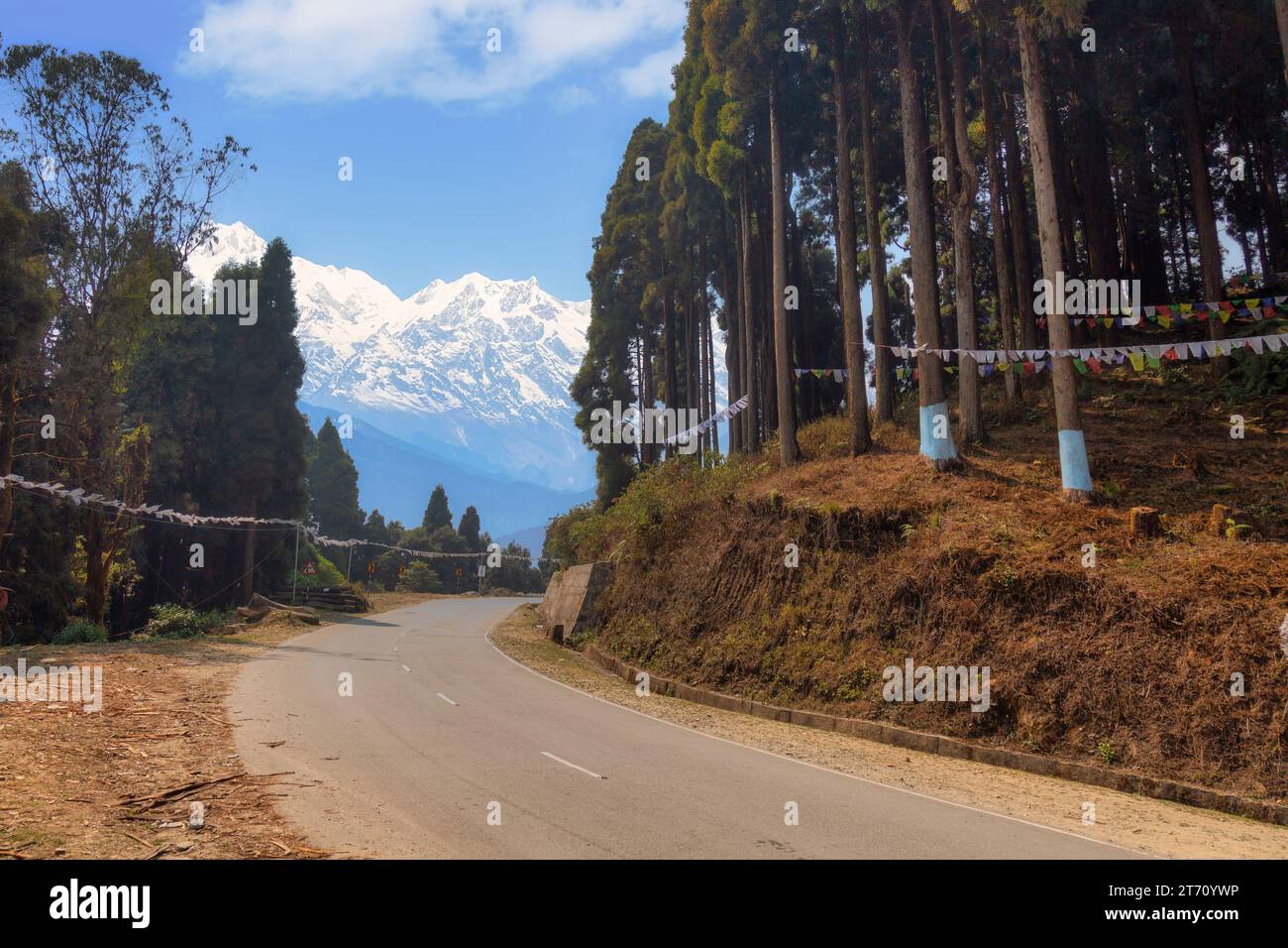 Scenic mountain road with view of the majestic snow-capped Kanchenjunga Himalaya mountain range at Tinchuley, Darjeeling, India Stock Photo