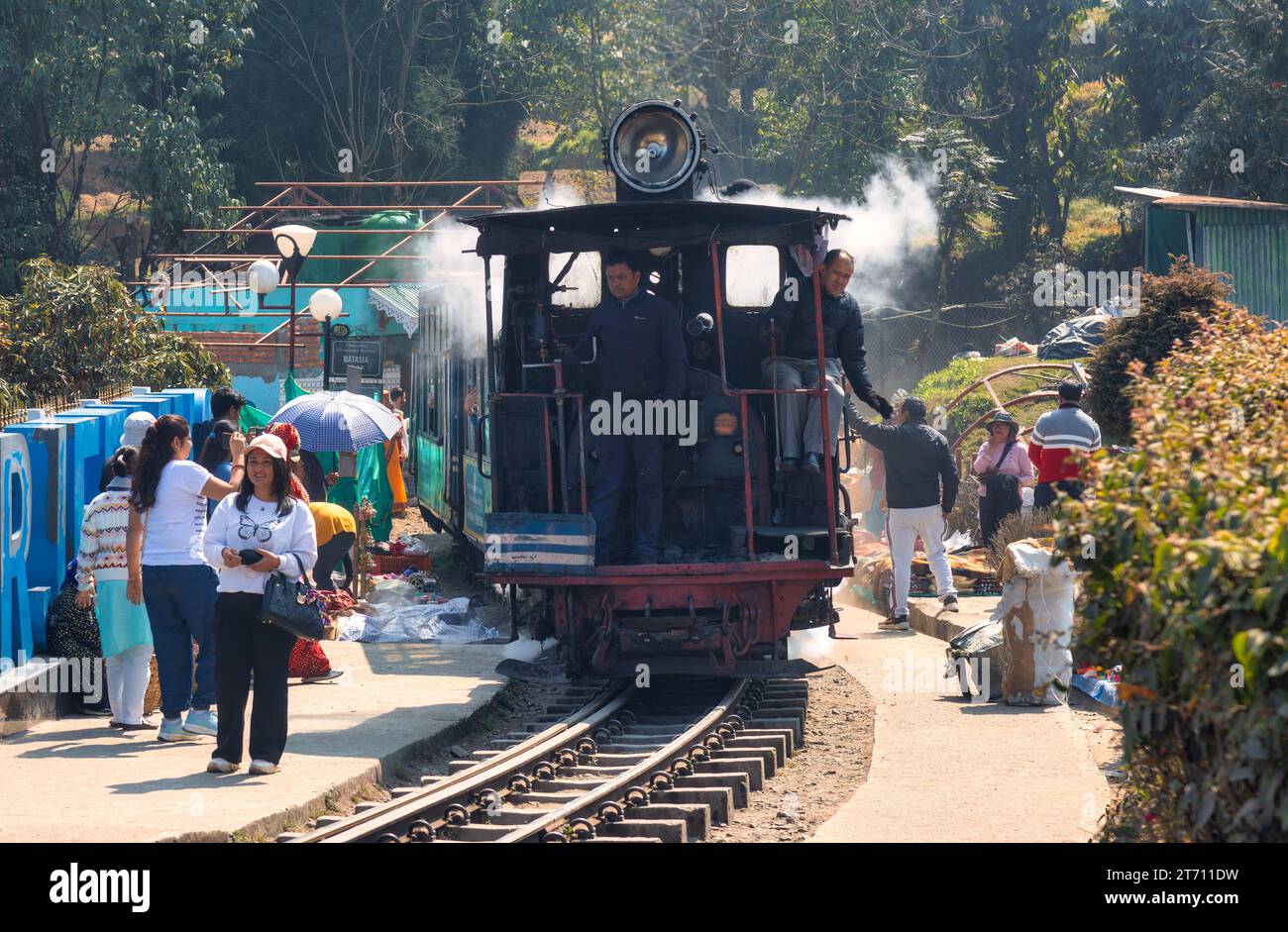 Toy train of the Darjeeling Himalayan railway with view of tourists at Batasia loop in West Bengal, India Stock Photo