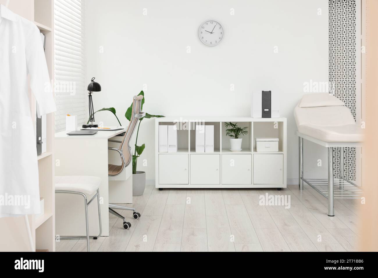 Modern medical office with doctor's workplace and examination table in ...