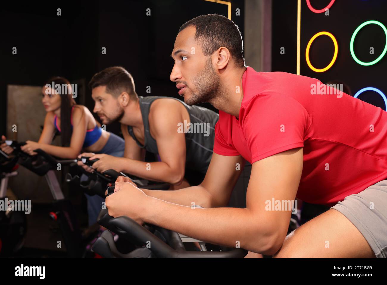 Group of people training on exercise bikes in fitness club Stock Photo ...
