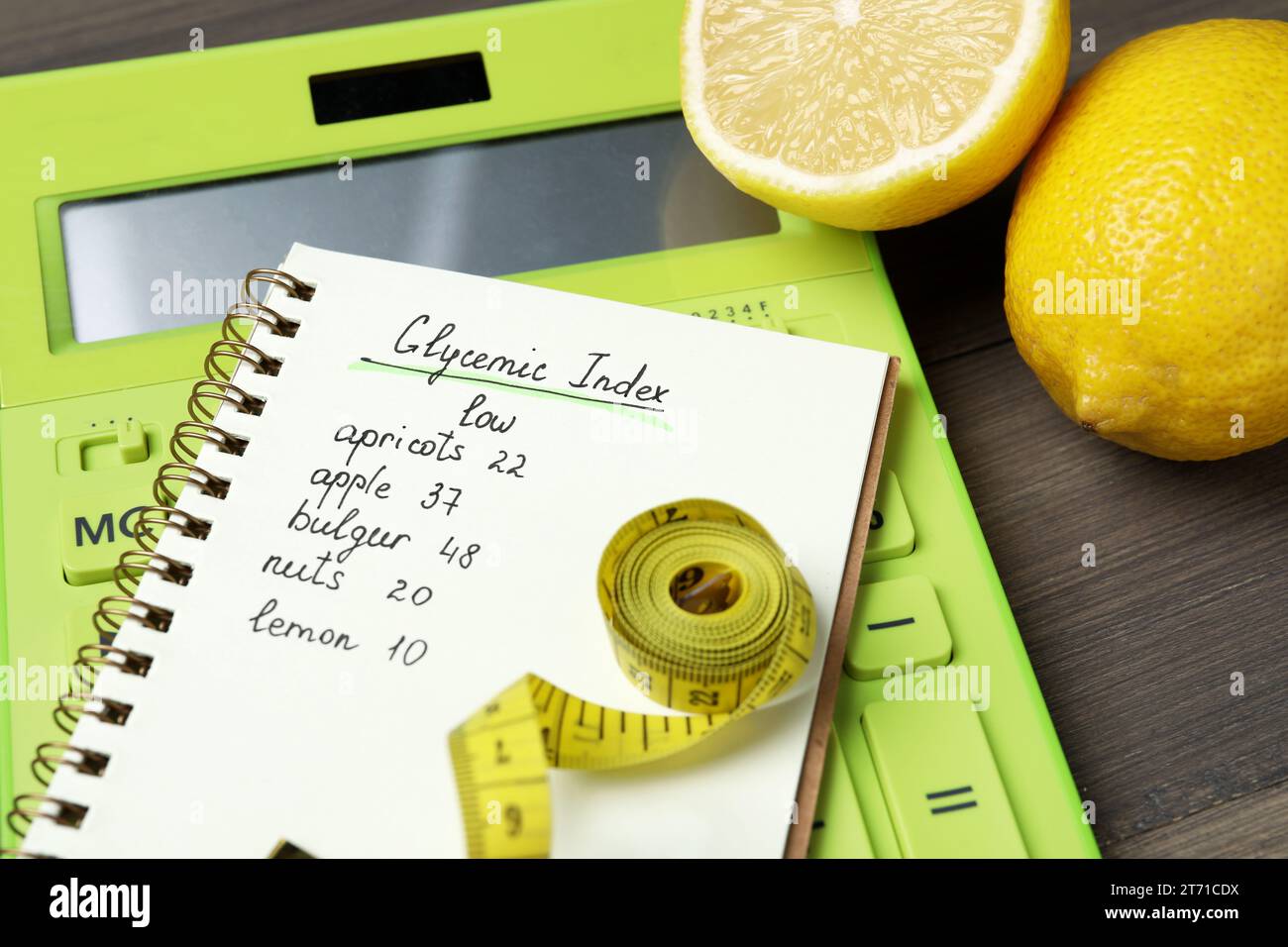 Notebook with products of low glycemic index, calculator, measuring tape and lemons on table, closeup Stock Photo