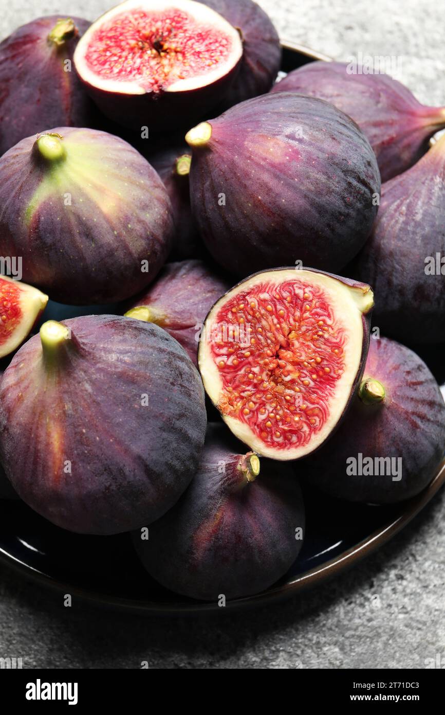 Whole and cut ripe figs on light grey textured table, above view Stock ...