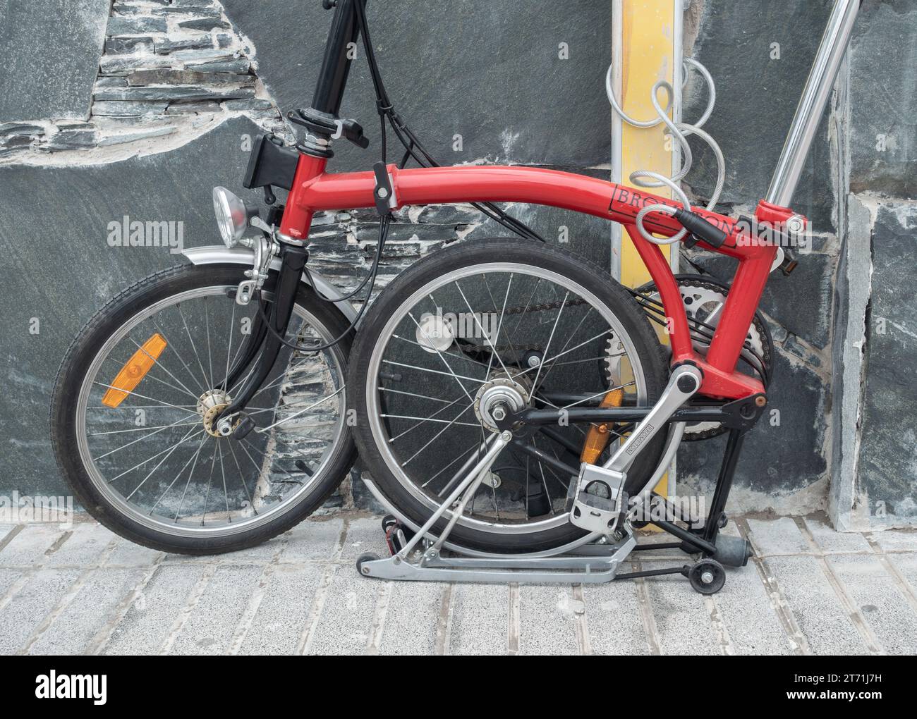 Folding Brompton bike, bicycle locked to post in street Stock Photo