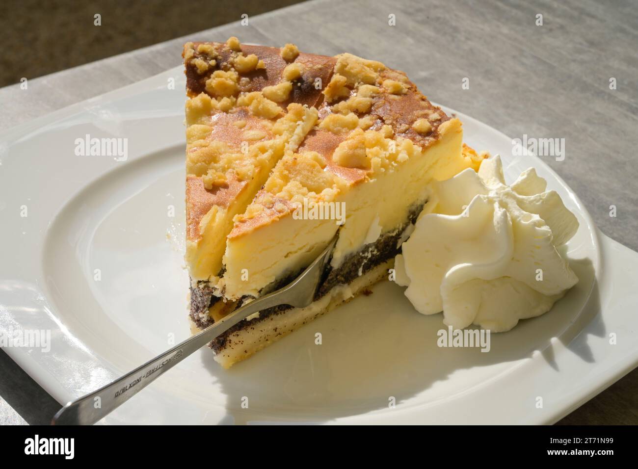 Käsekuchen mit Streuseln auf Mohnboden mit Schlagsahne Stock Photo