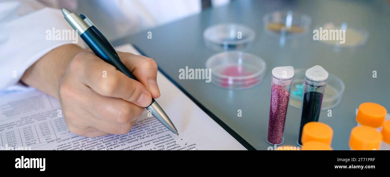 Banner of unrecognizable female scientist hand filling investigation form about dangers of small plastic particles on glitter. Close up of woman chemi Stock Photo