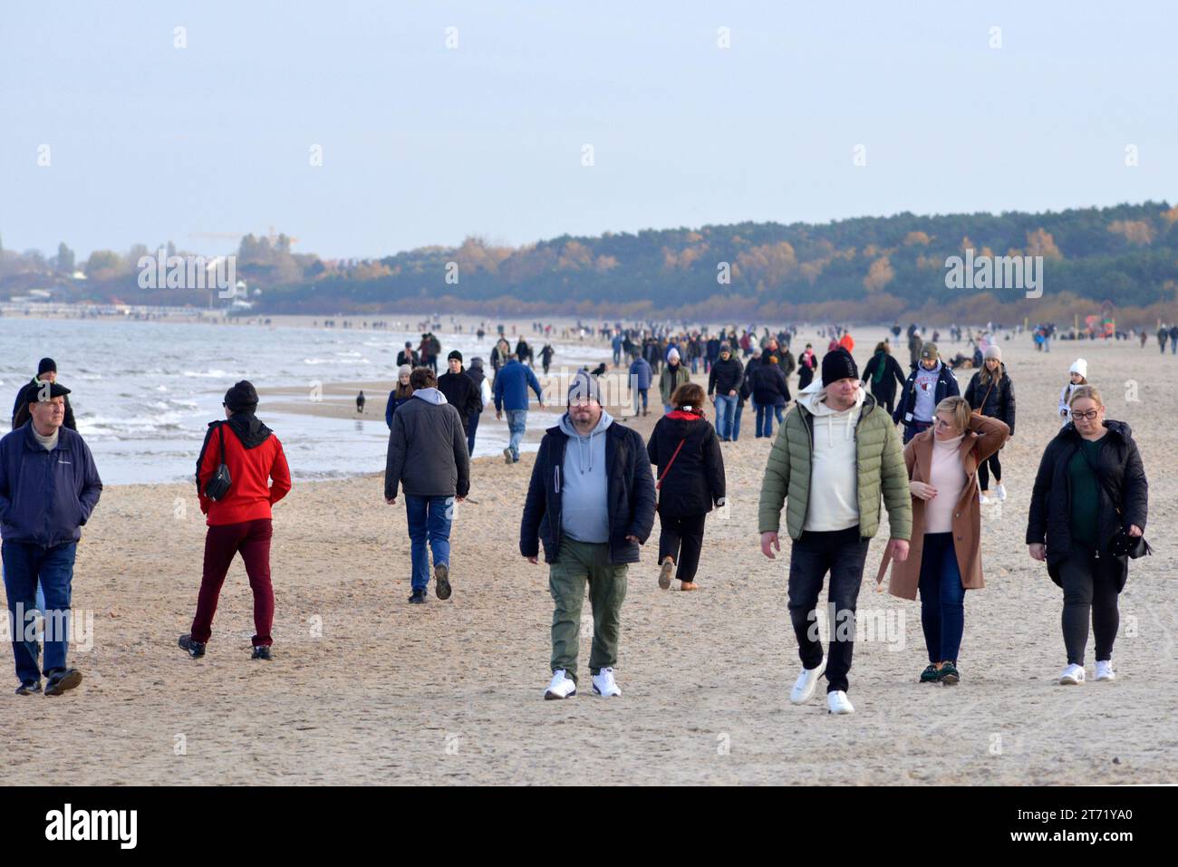 People with jackets walking on the Gdansk beach in cold weather in Gdansk, Poland, Europe, EU Stock Photo