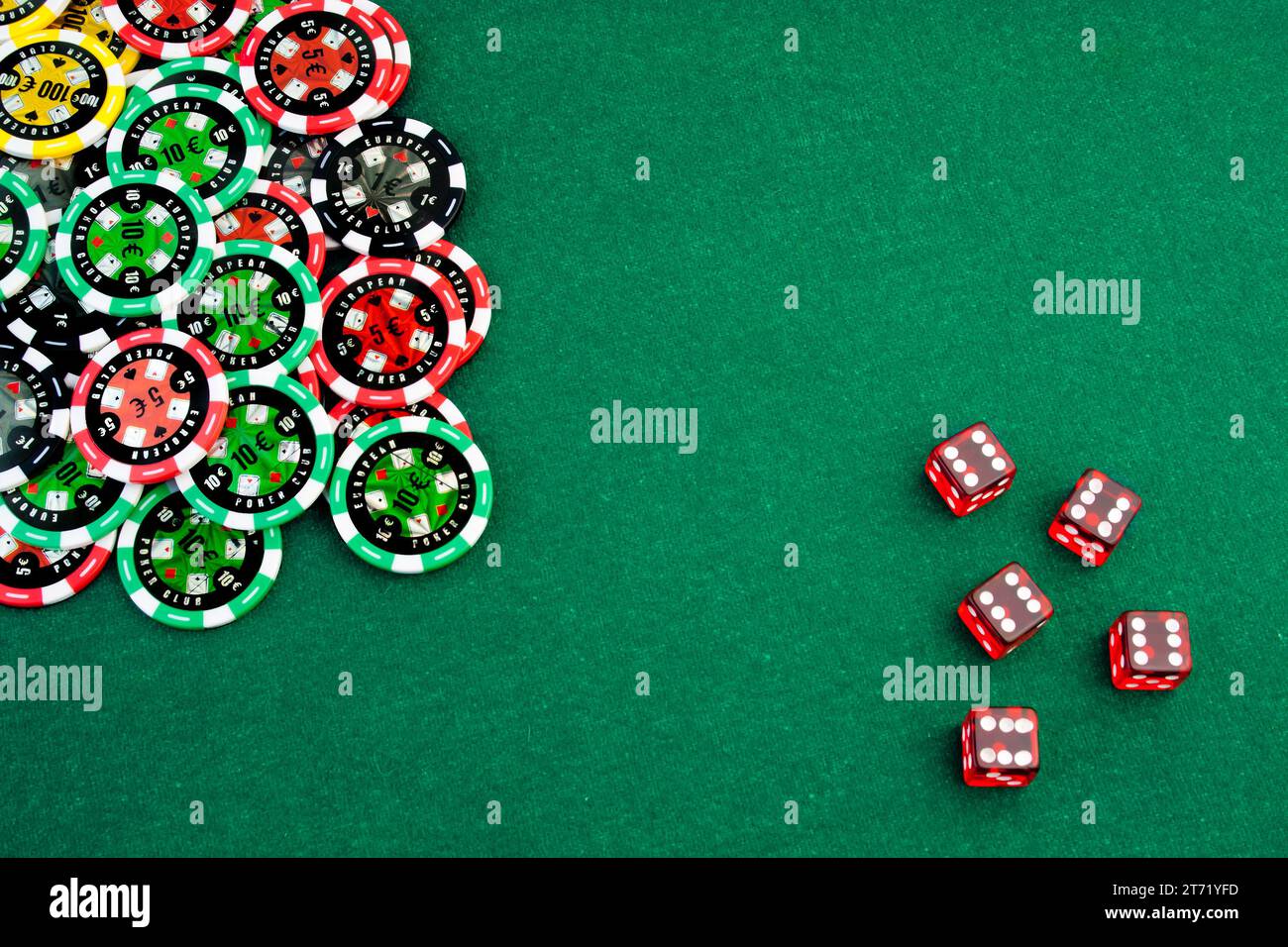 Gambling chips and dice in corner in of a green fabric background Stock Photo