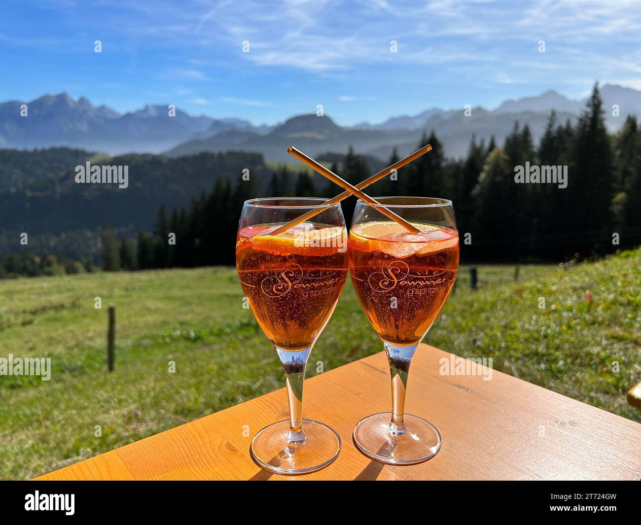 The two drinks in glasses on a table, with a mountainous landscape in the background in Unken, Austria Stock Photo