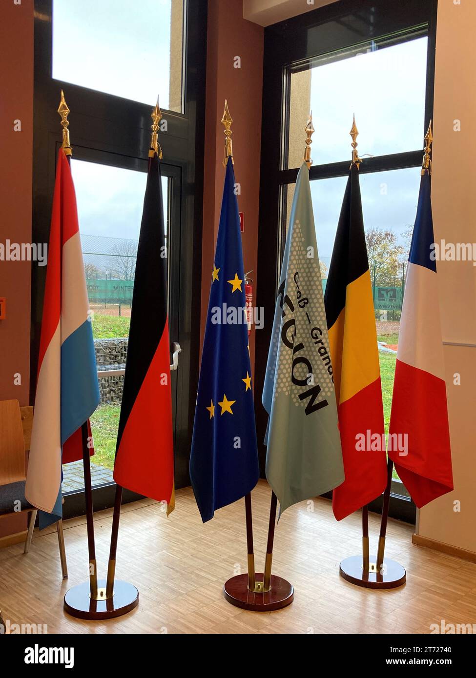 Tawern, Germany. 13th Nov, 2023. Flags of the various partners from Germany, Luxembourg, France and Belgium stand side by side at the interim summit of the Greater Region. (to dpa 'Greater region plans joint office for civil protection') Credit: Birgit Reichert/dpa/Alamy Live News Stock Photo