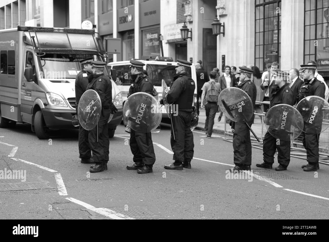 Police on duty in Fleet street, central London. Black and white image of uniform Metropolitan police preparing for crowd control of a demonstration, protest. Streets. London. Stock Photo