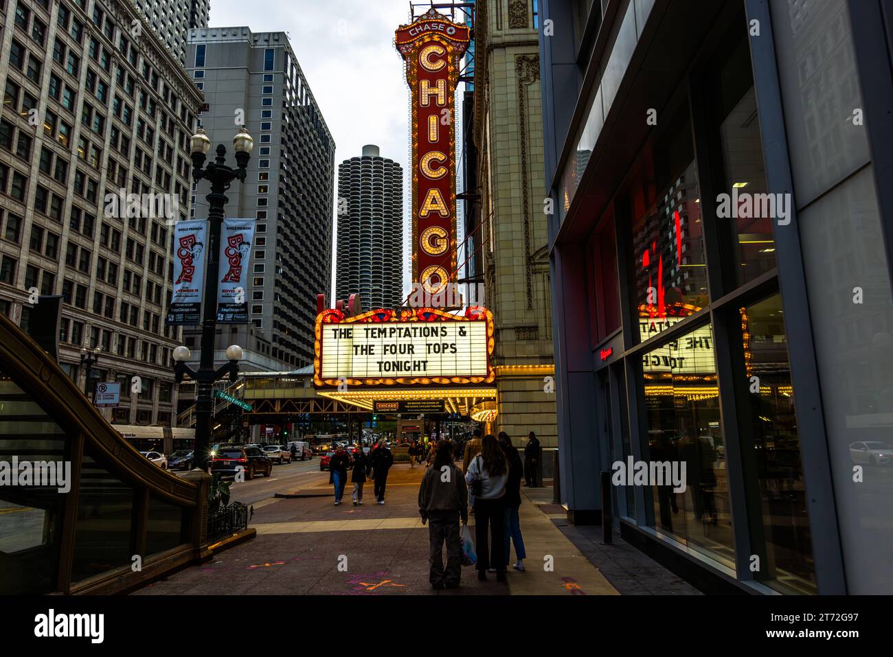 The Chicago Theatre featuring the Temptations and the four Tops in Chicago, United States. In the background is one of the two marina towers, one of the city's most famous buildings in the shape of a corn cob Stock Photo