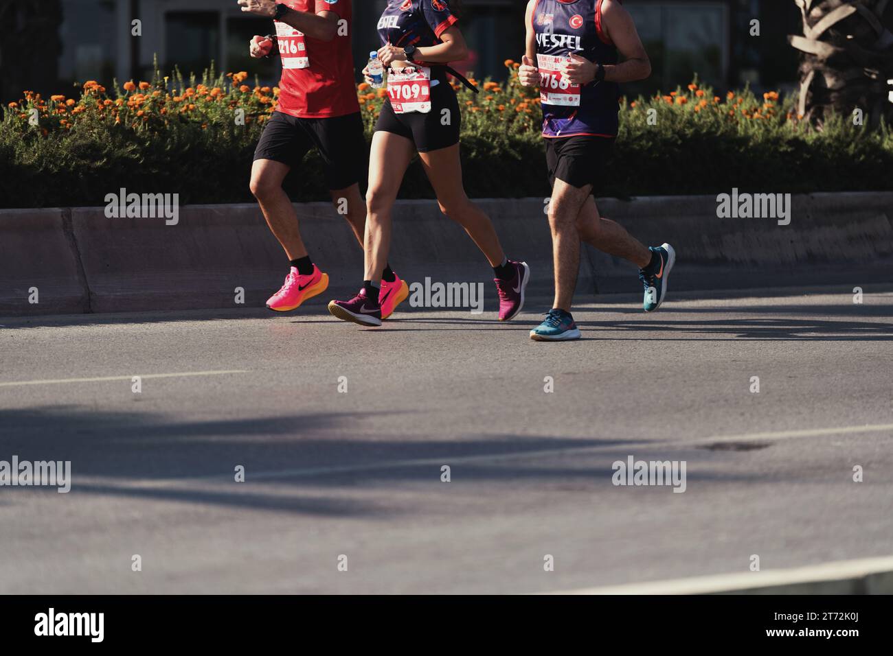 Izmir, Turkey, September 10, 2023: A dynamic close-up captures the stride and athletic footwear of three marathon runners, featuring one woman and two Stock Photo