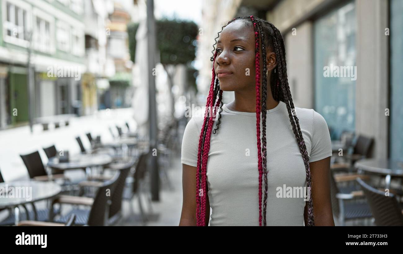 Cool african american woman with braids, seriously looking sideways on ...