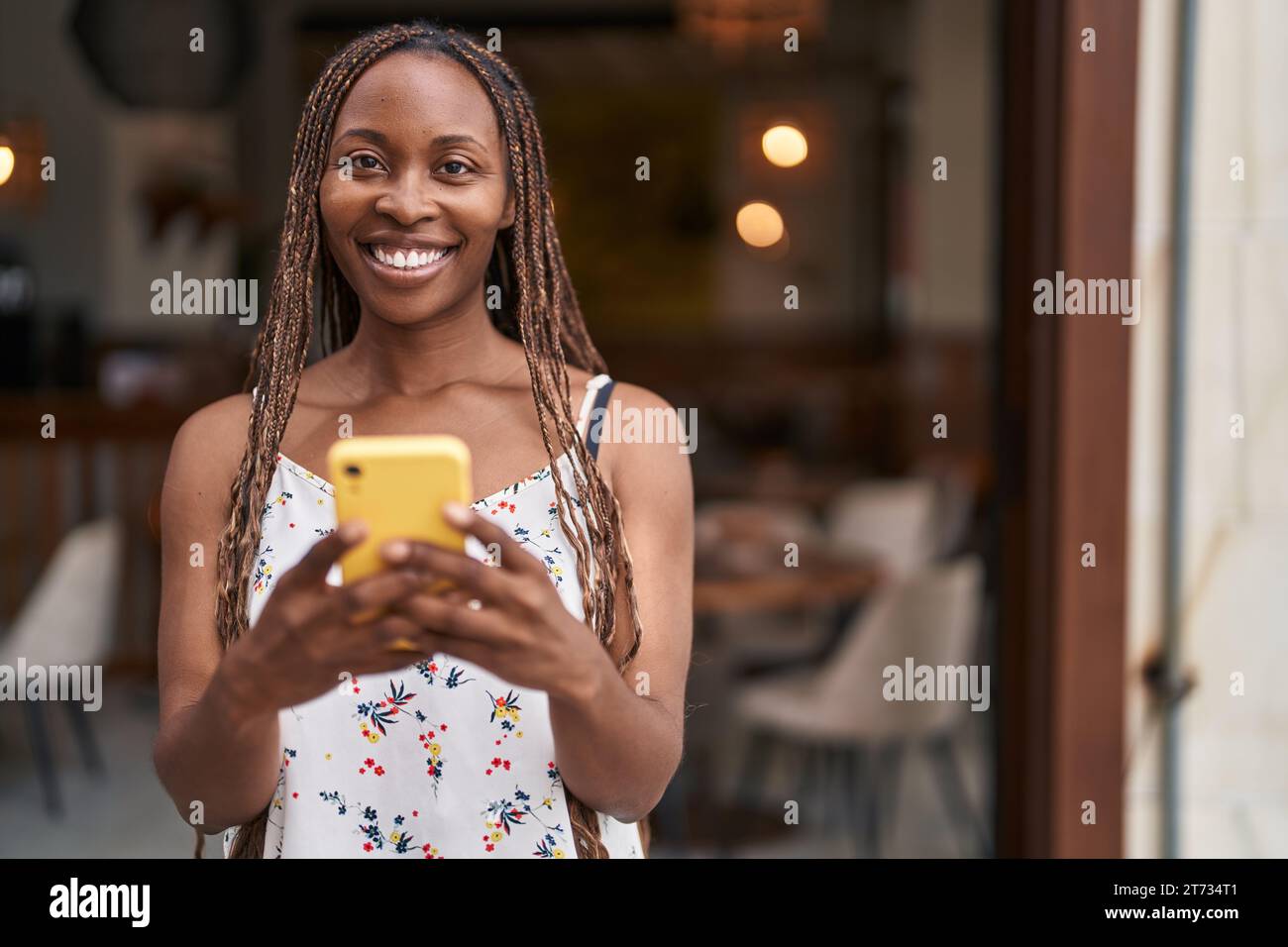 African american woman smiling confident using smartphone at coffee ...