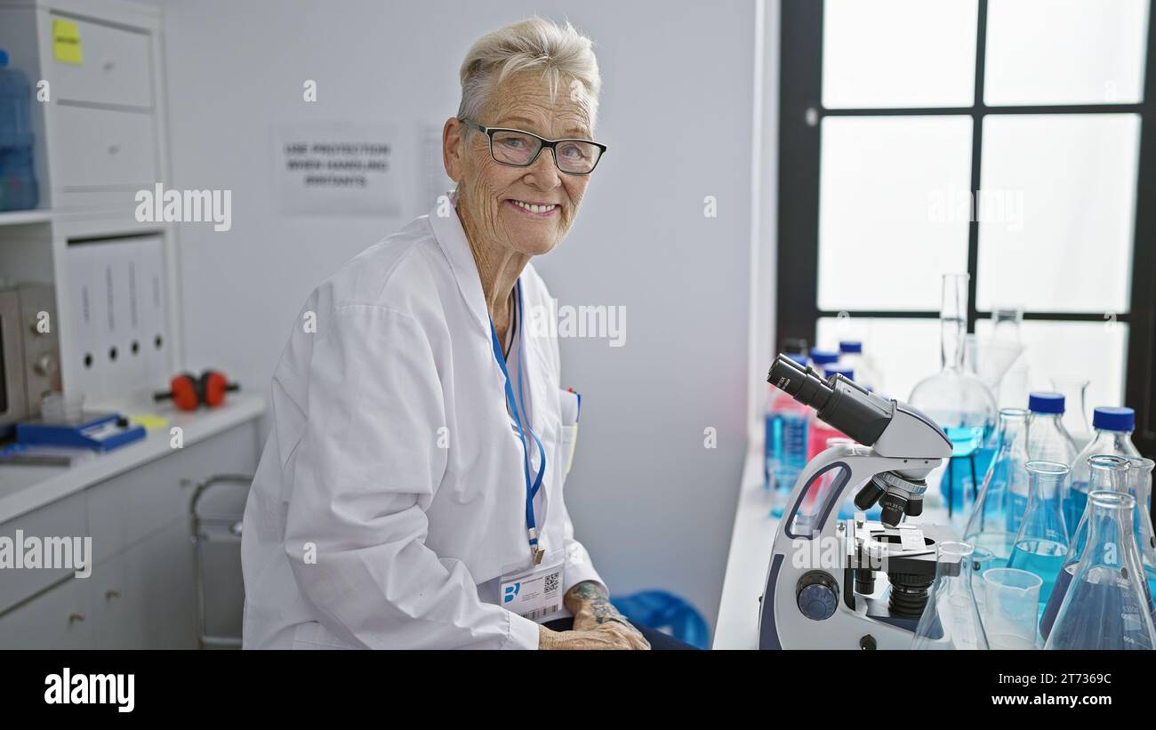 Confident, smiling senior woman scientist with grey hair, happy at her ...