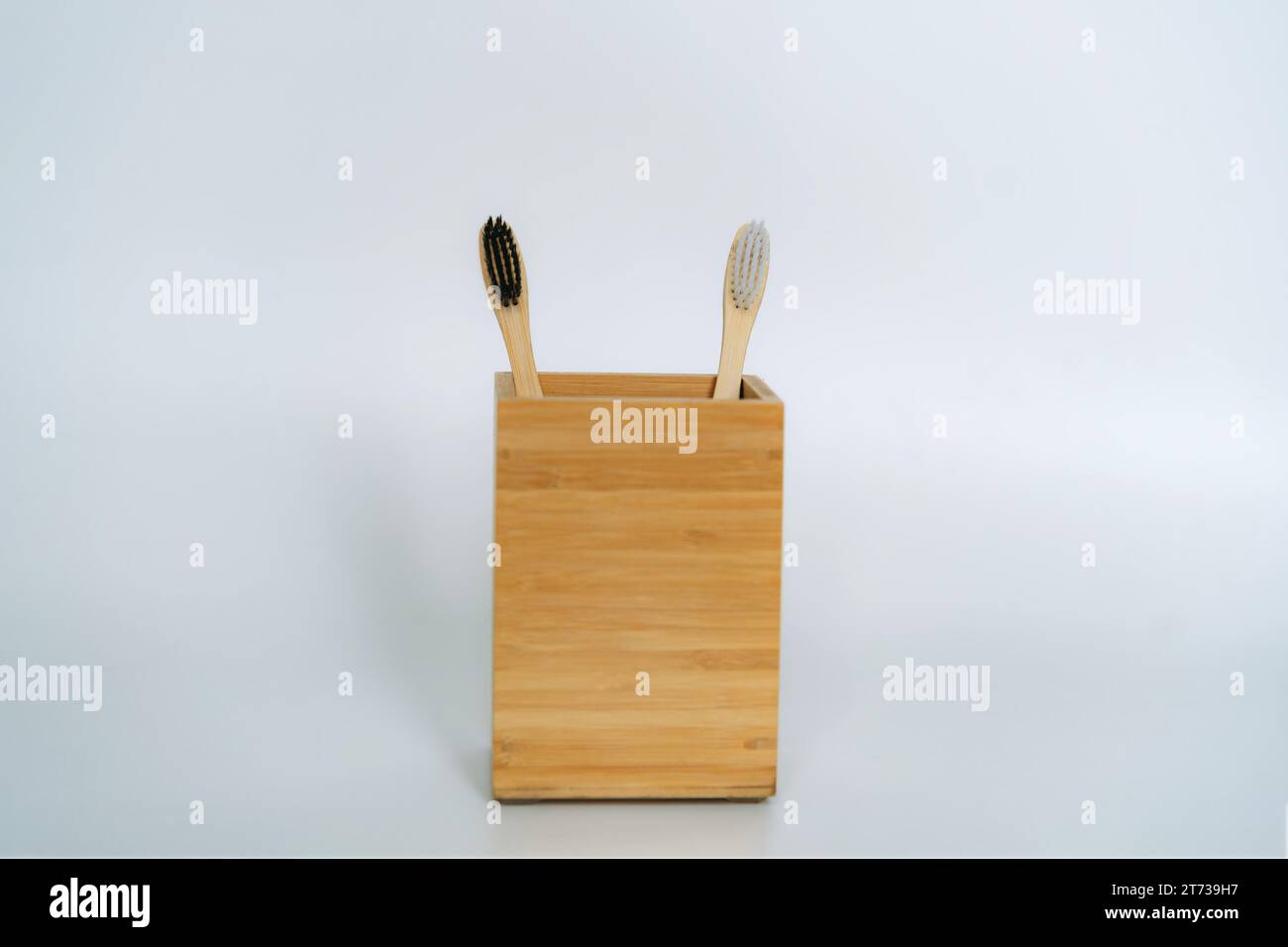 two toothbrushes in bamboo holder on white background Stock Photo - Alamy