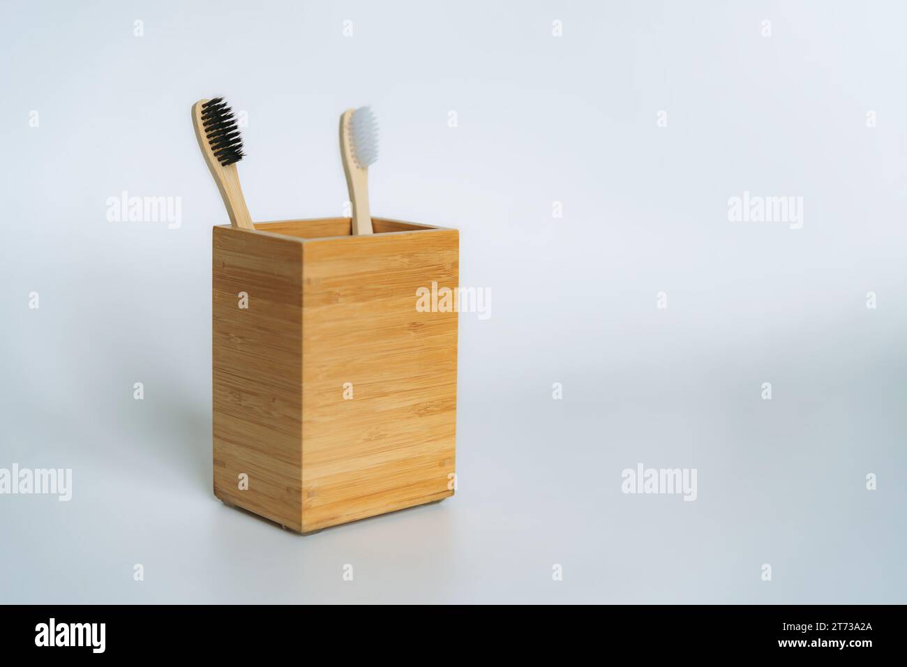 two toothbrushes in bamboo holder on white background Stock Photo - Alamy