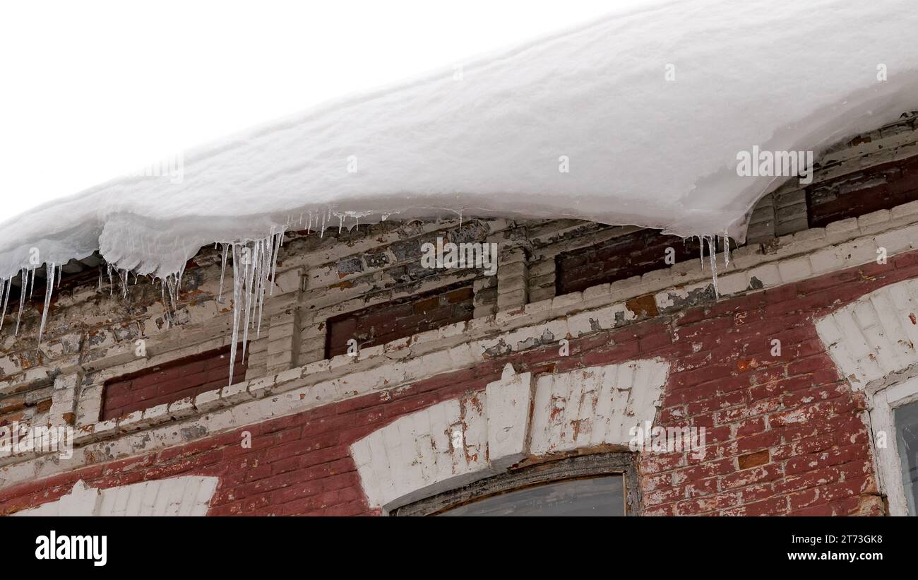 A huge snow block dangerously hangs down from the building karziz ...