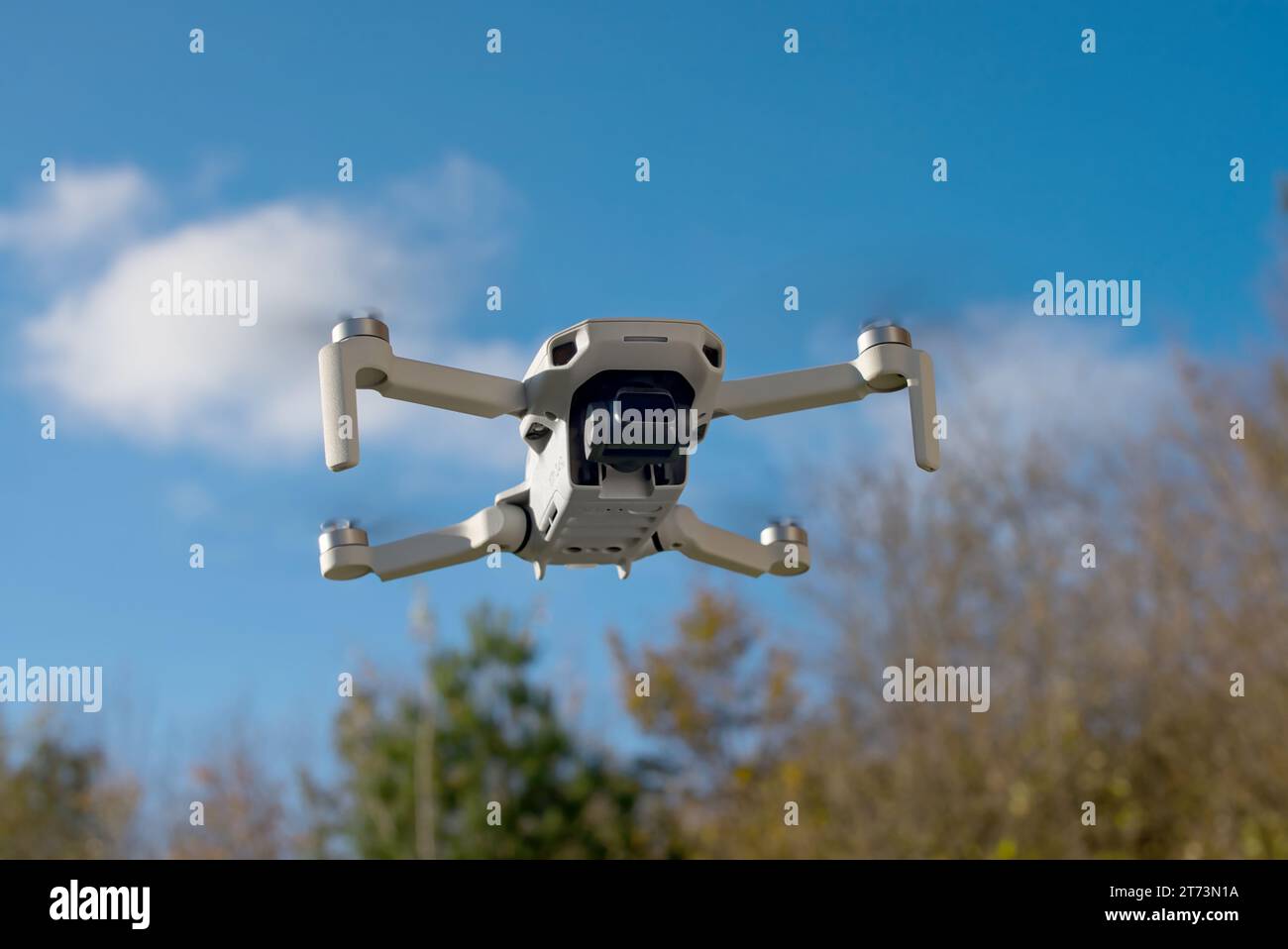 A drone hovering in front of autumn trees that deliver nice bokeh. An ND Filter is attached to the drone. Stock Photo