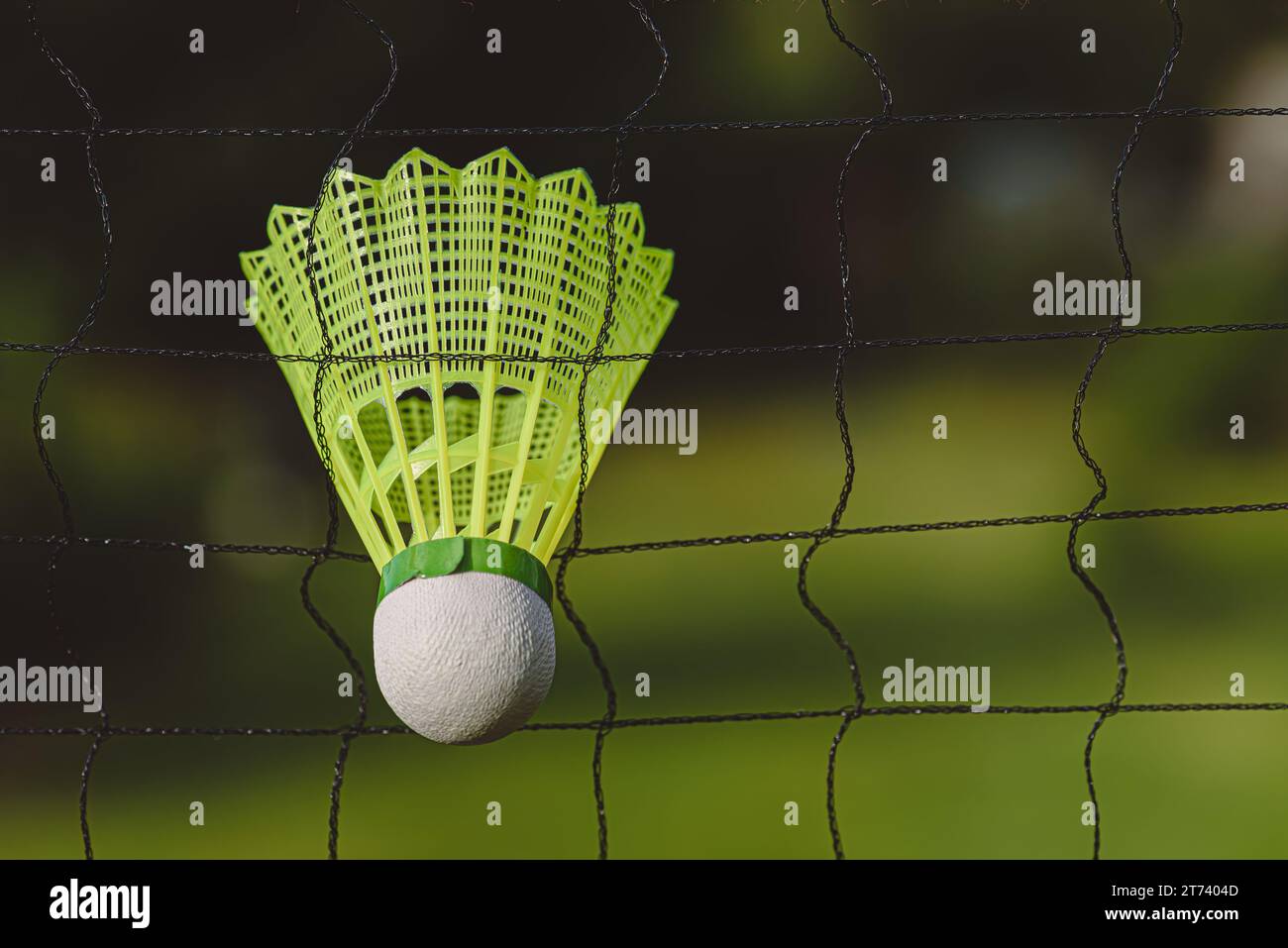 Badminton shuttlecock (Birdie) in badminton net outdoors. Background