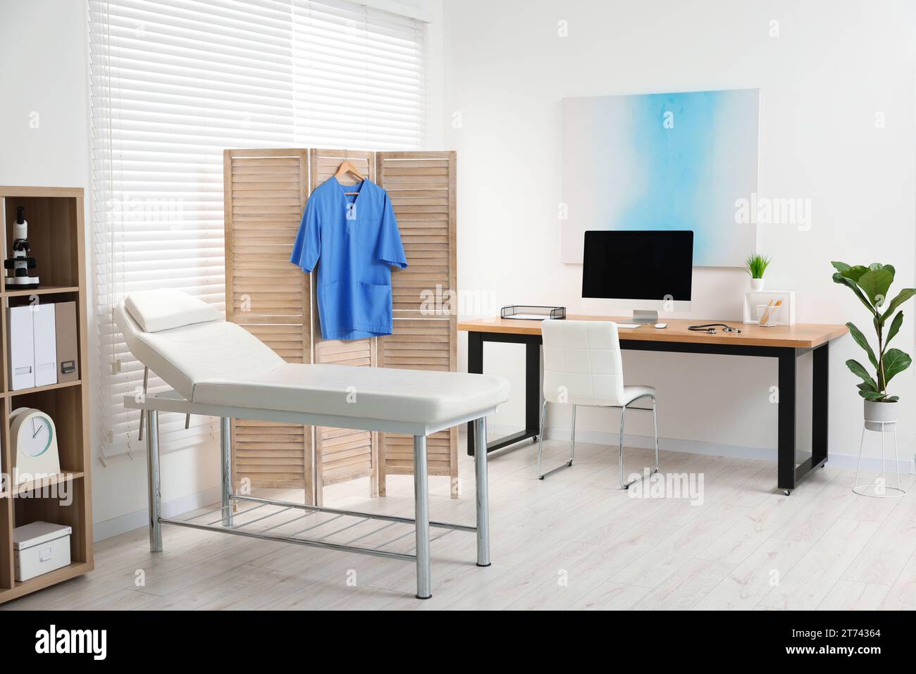 Modern medical office with doctor's workplace and examination table in ...
