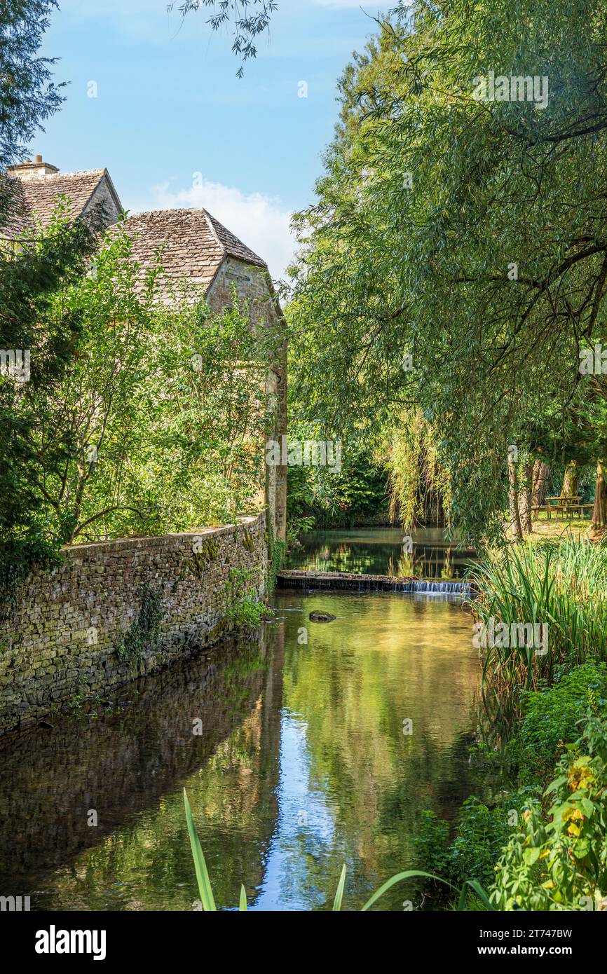18th century Baunton Mill beisde the infant River Churn in the Cotswold village of Baunton, Gloucestershire UK Stock Photo
