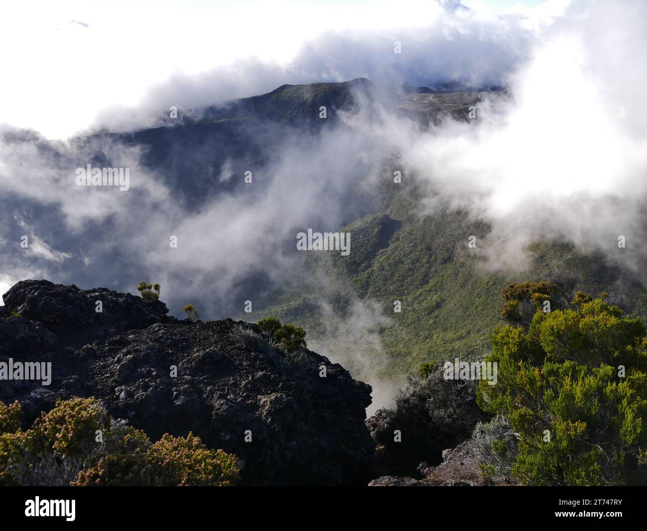 Vertiginous landscape near Commerson crater, on the way to Fournaise volcano, Reunion island. Mountains in the midst of clouds in la Réunion. Stock Photo