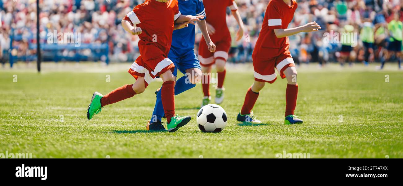 Football soccer match for children. Boys playing a football game in a school tournament. Picture of kids competition while playing a European football Stock Photo