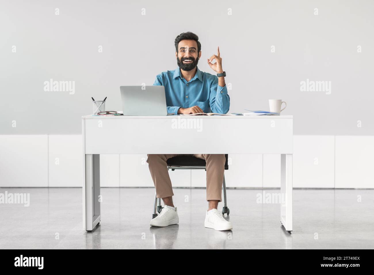 Indian businessman having idea, sitting at desk Stock Photo