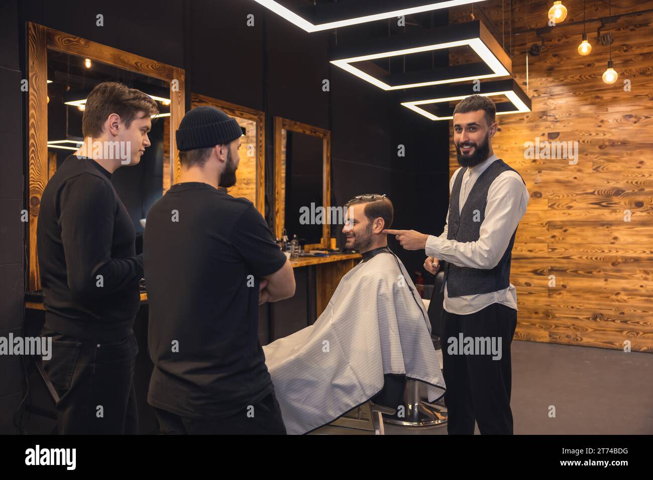 Barber teaches student to make men's hairstyles on model Stock Photo