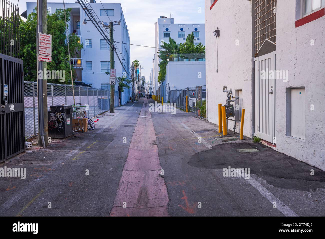 View of narrow street leading to Ocean Drive in Miami Beach with houses and parking along road. Florida. USA. Stock Photo