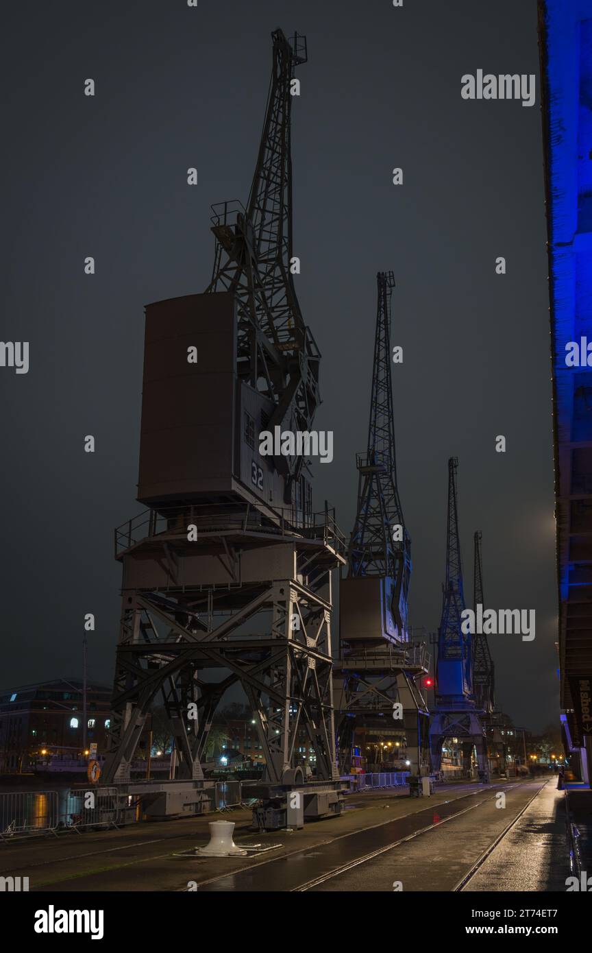 The illuminated cranes along the waterfront in front of the M-Shed in ...