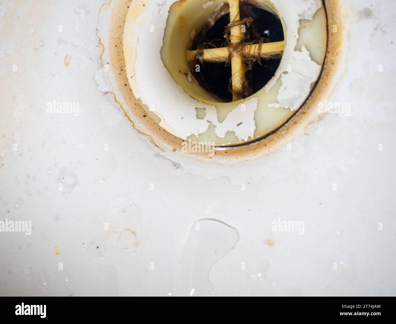 Clogged and dirty drain in the bathroom. Black dots on bathroom enamel