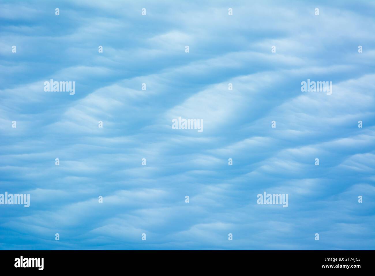Abstract blue tinted cloud texture with a wavy, dune pattern. Stock Photo